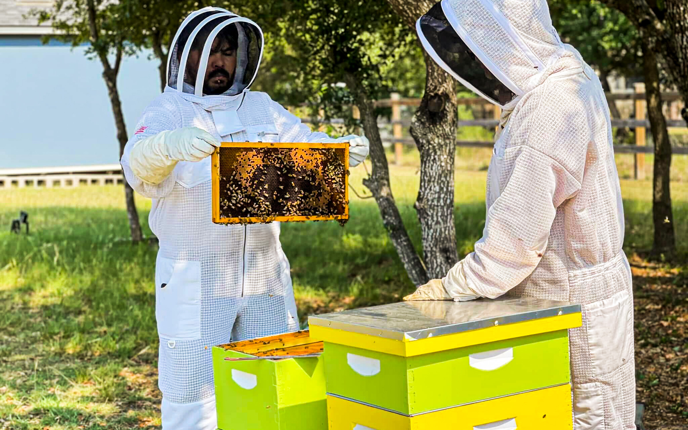 Mentor Tim Schmitz (right) teaches NewBEE James Burns about beekeeping.